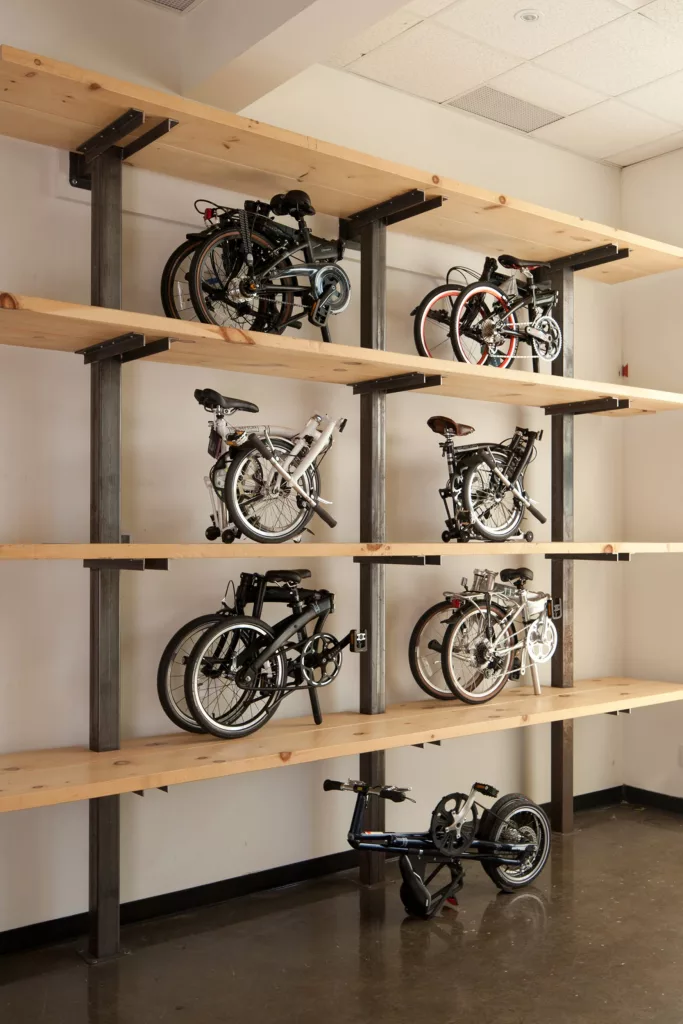 Des tablettes de bois et d'acier servent de présentoirs pour des vélos pliables.