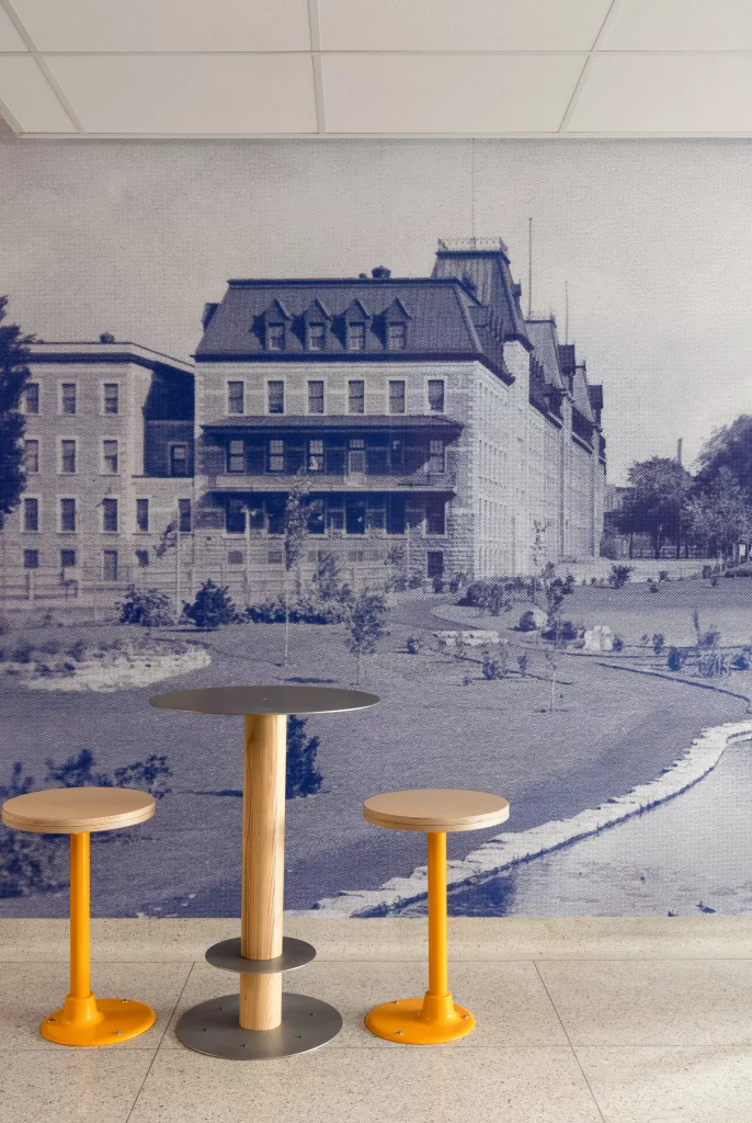 Un détail de mobilier devant une murale de photo historique au Collège-Notre-Dame.