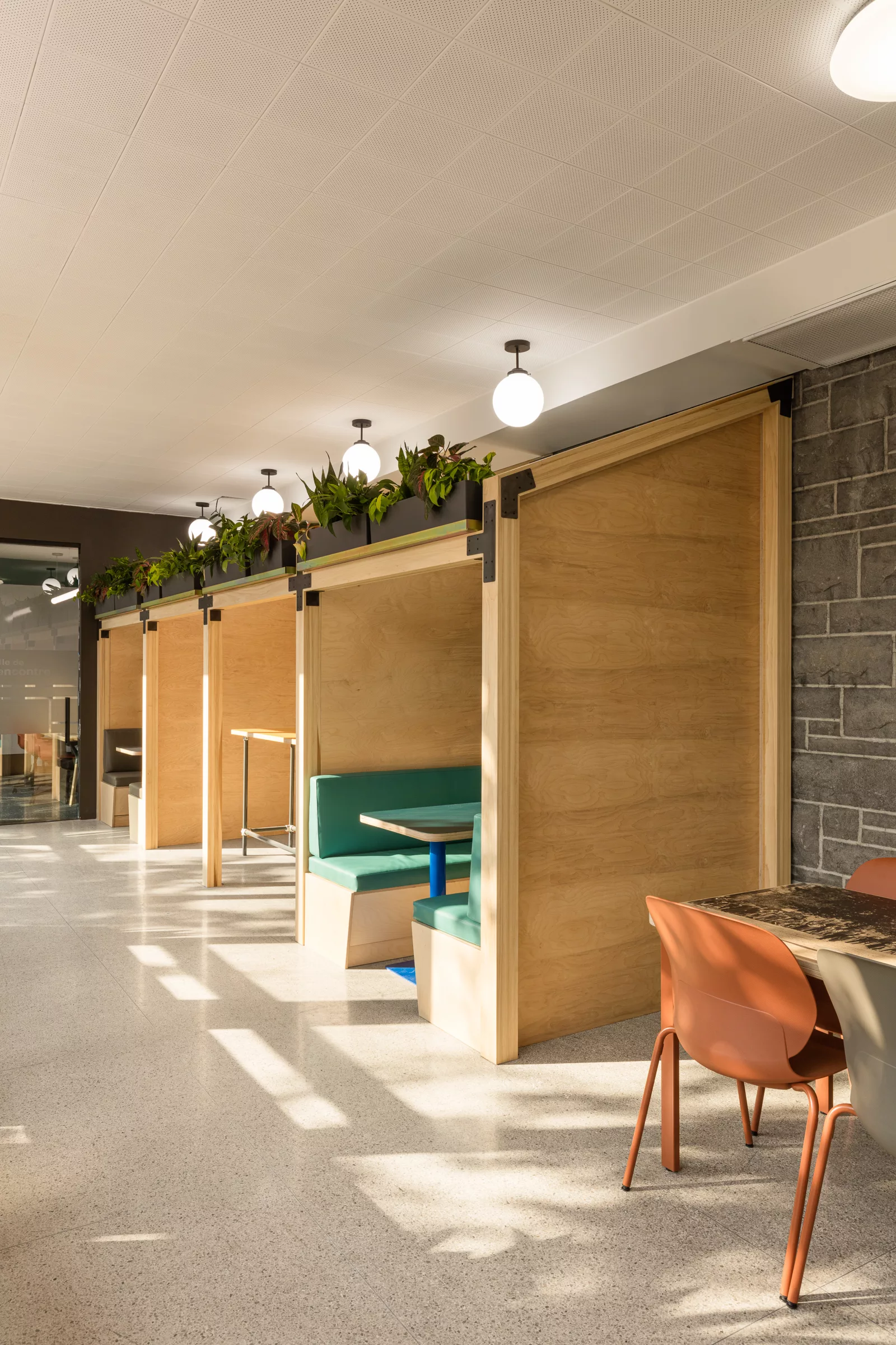 Une vue large de l'espace de travail au Collège-Notre-Dame. On y voit les différentes alcôves aménagées pour du travail dans une structure de bois clair.