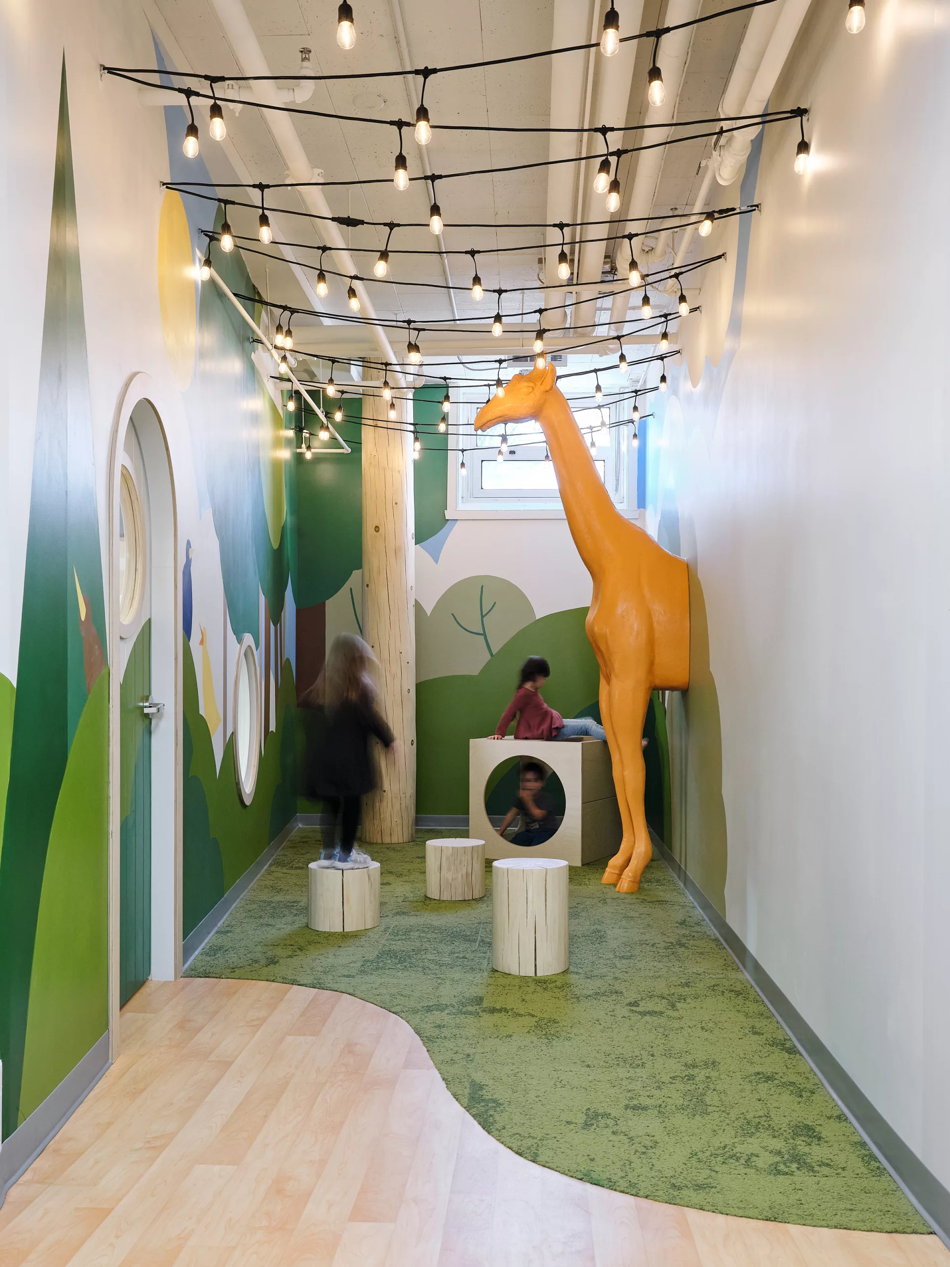 Vue du bout du couloir. Une girafe en volume habille l'espace.