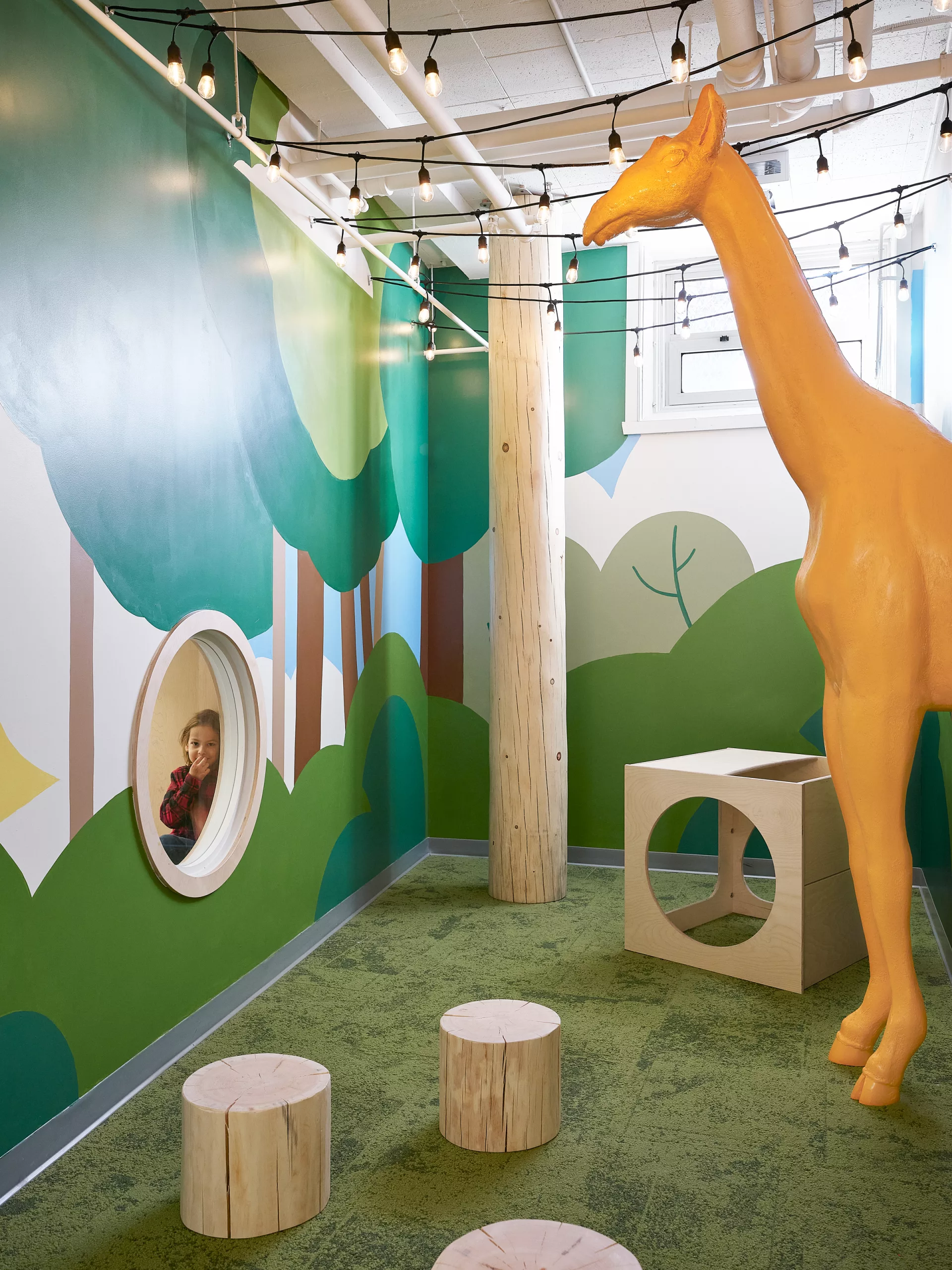 Vue du bout du couloir. Une girafe en volume habille l'espace.