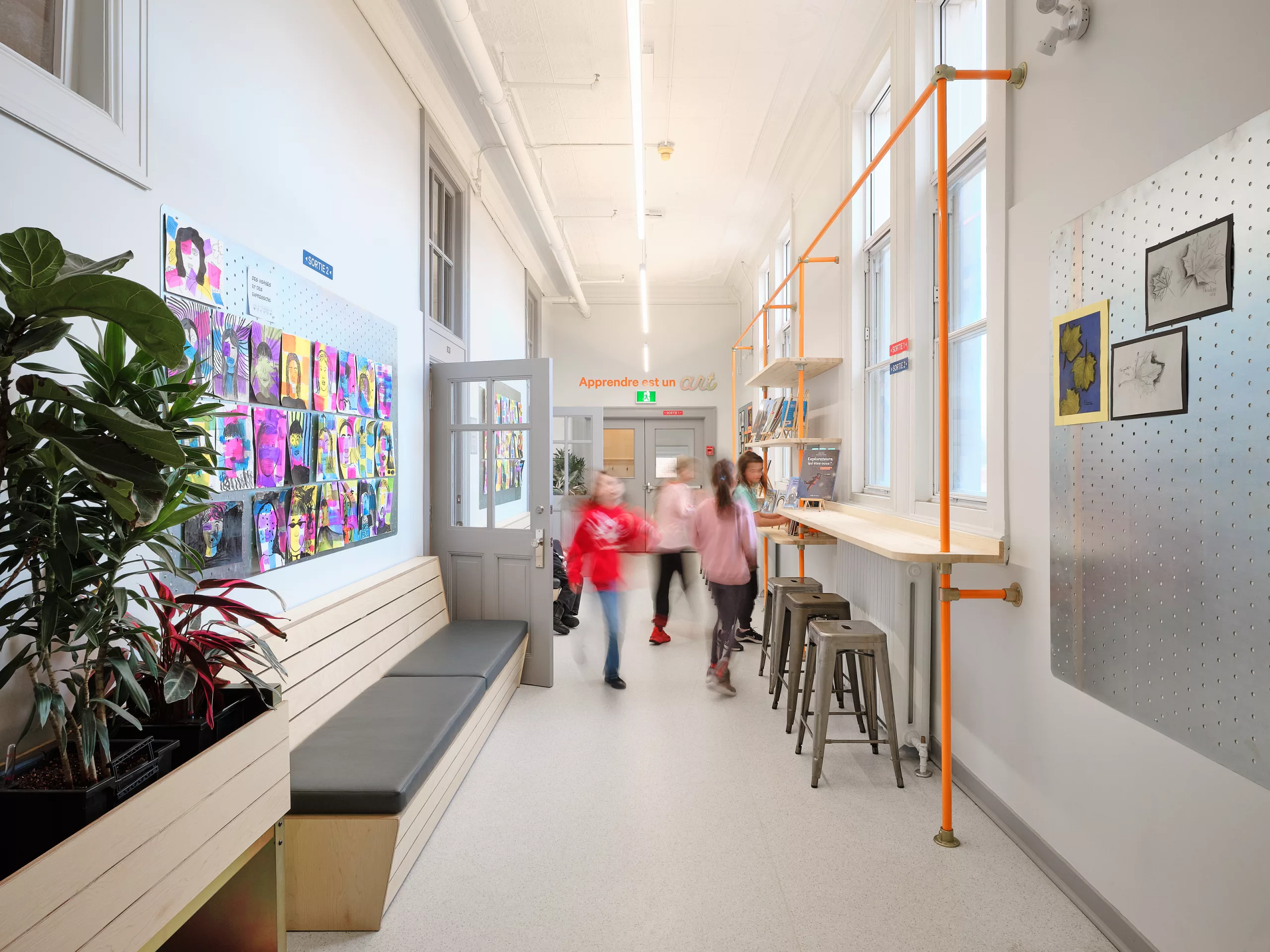Vue du couloir du premier étage, réaménagé par taktik Design. Des élèves utilisent l'espace.
