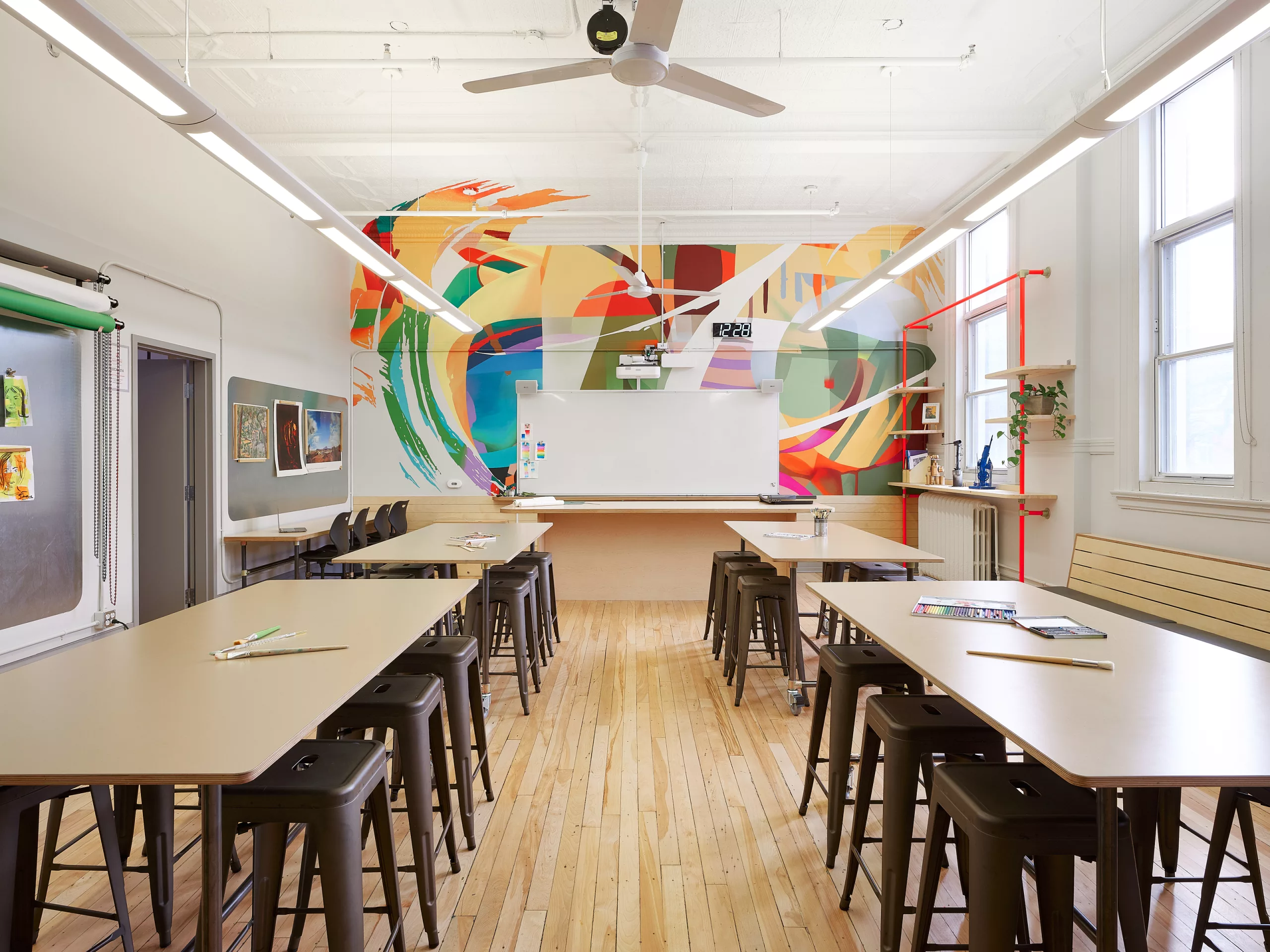 Une vue générale d'une des salles de classe à l'étage du Collège Sainte-Anne Buissonnière. On y voit une murale créée par Projet Tyxna.