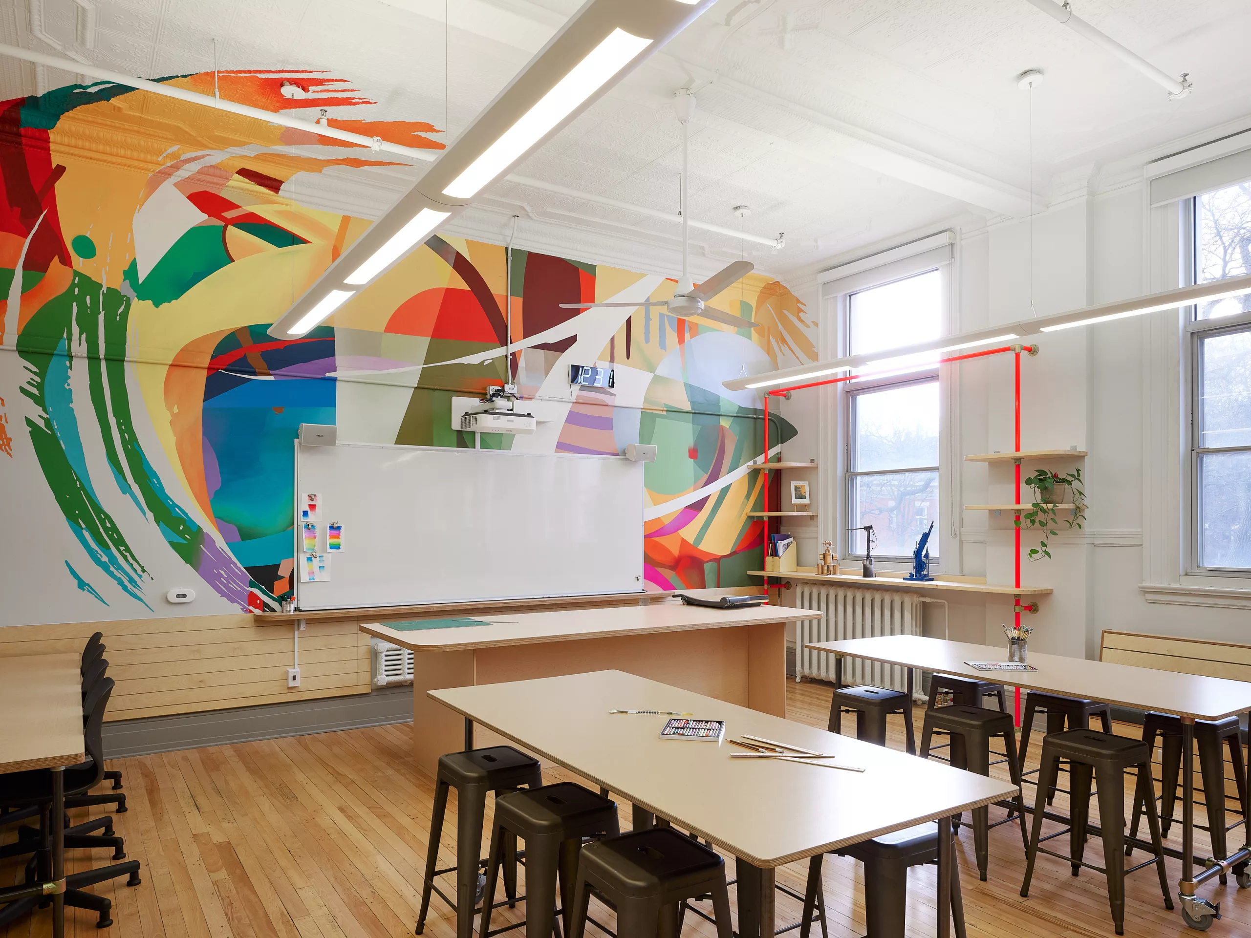 Une vue générale d'une des salles de classe à l'étage du Collège Sainte-Anne Buissonnière. On y voit une murale créée par Projet Tyxna.