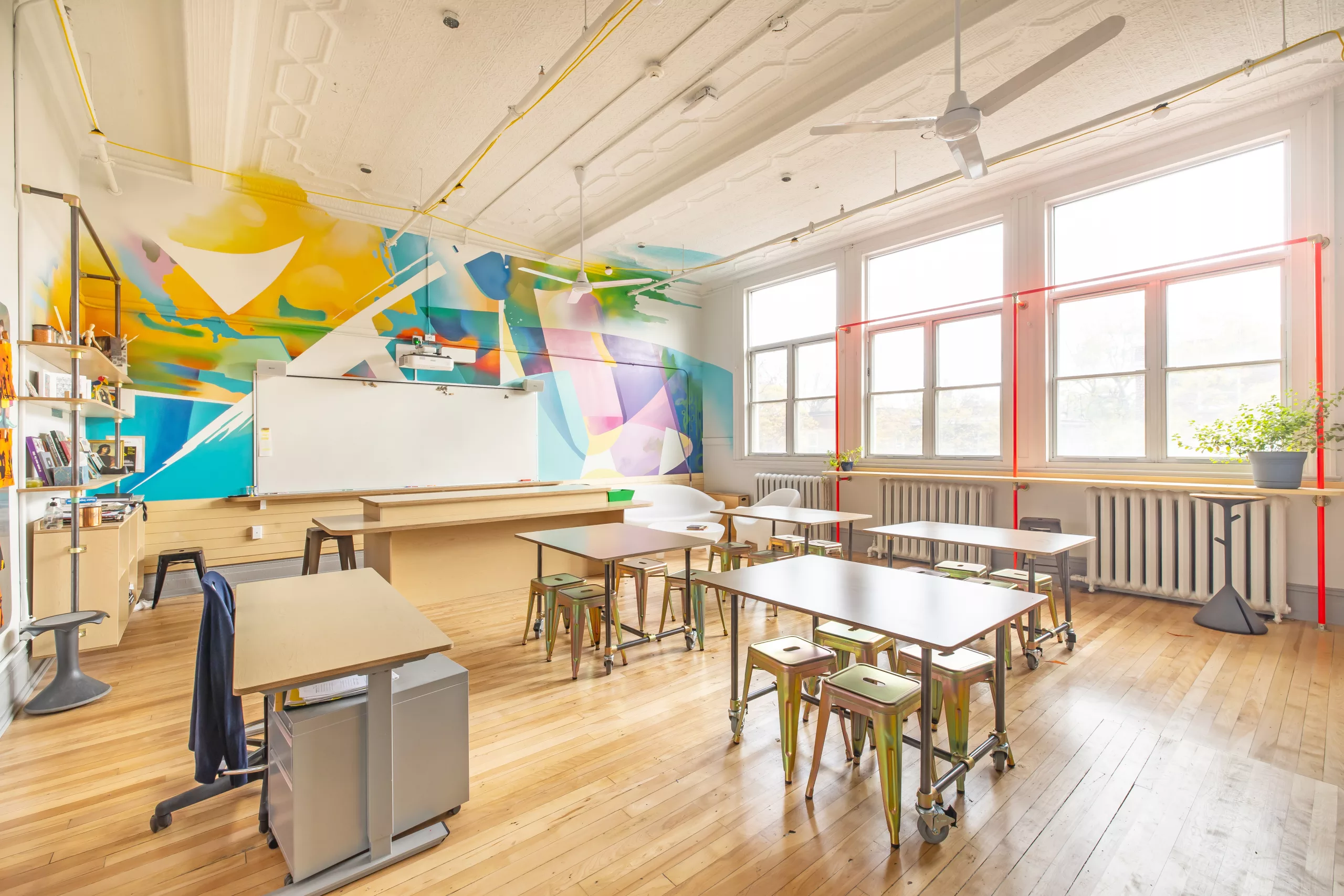 Une vue générale d'une des salles de classe à l'étage du Collège Sainte-Anne Buissonnière. On y voit une murale créée par Projet Tyxna.