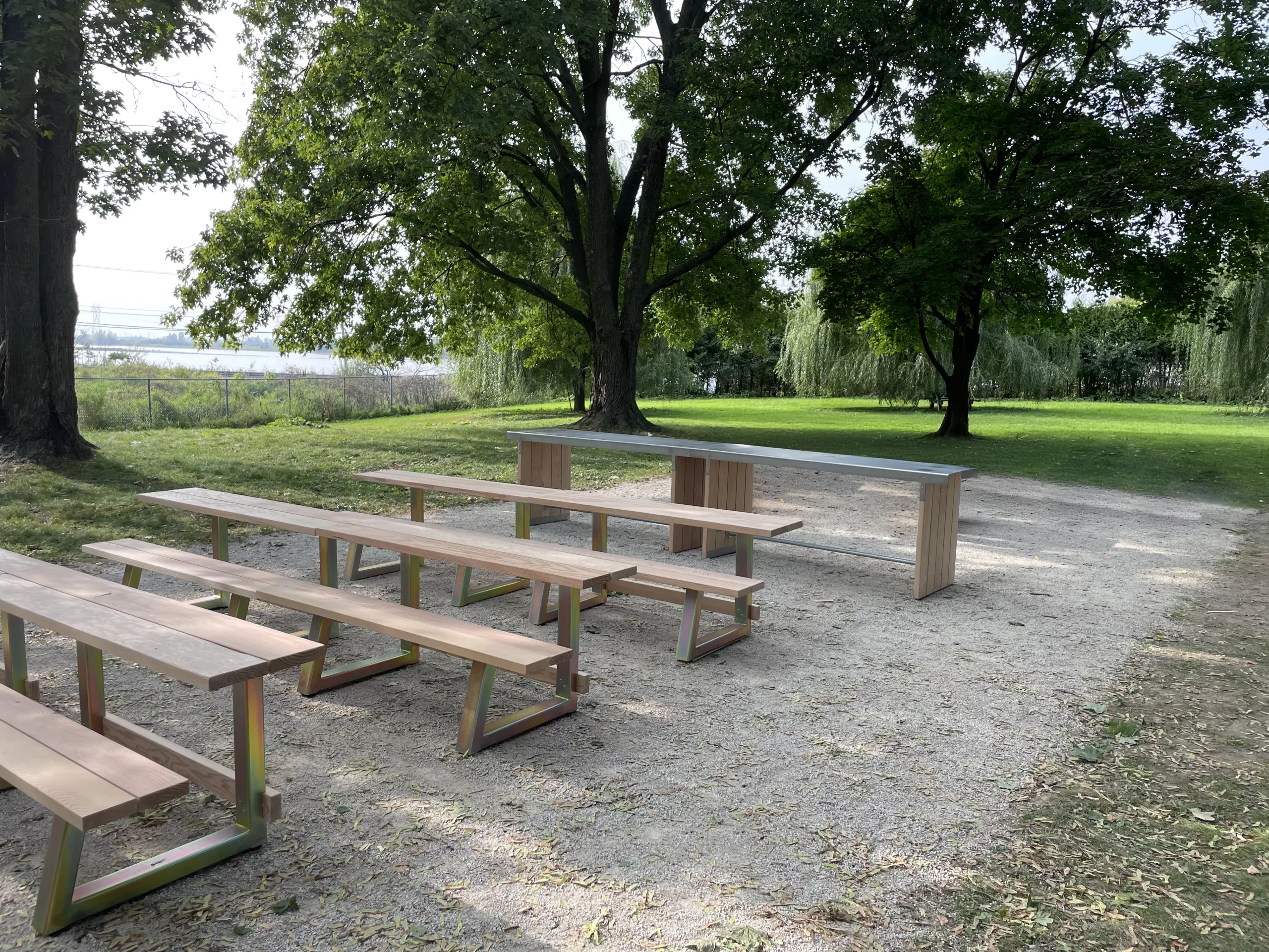 Deux ilots Rabaska, faits de bois et d'acier inoxydable disposé au bout de mobiliers de tables de pique-nique à l'extérieur.