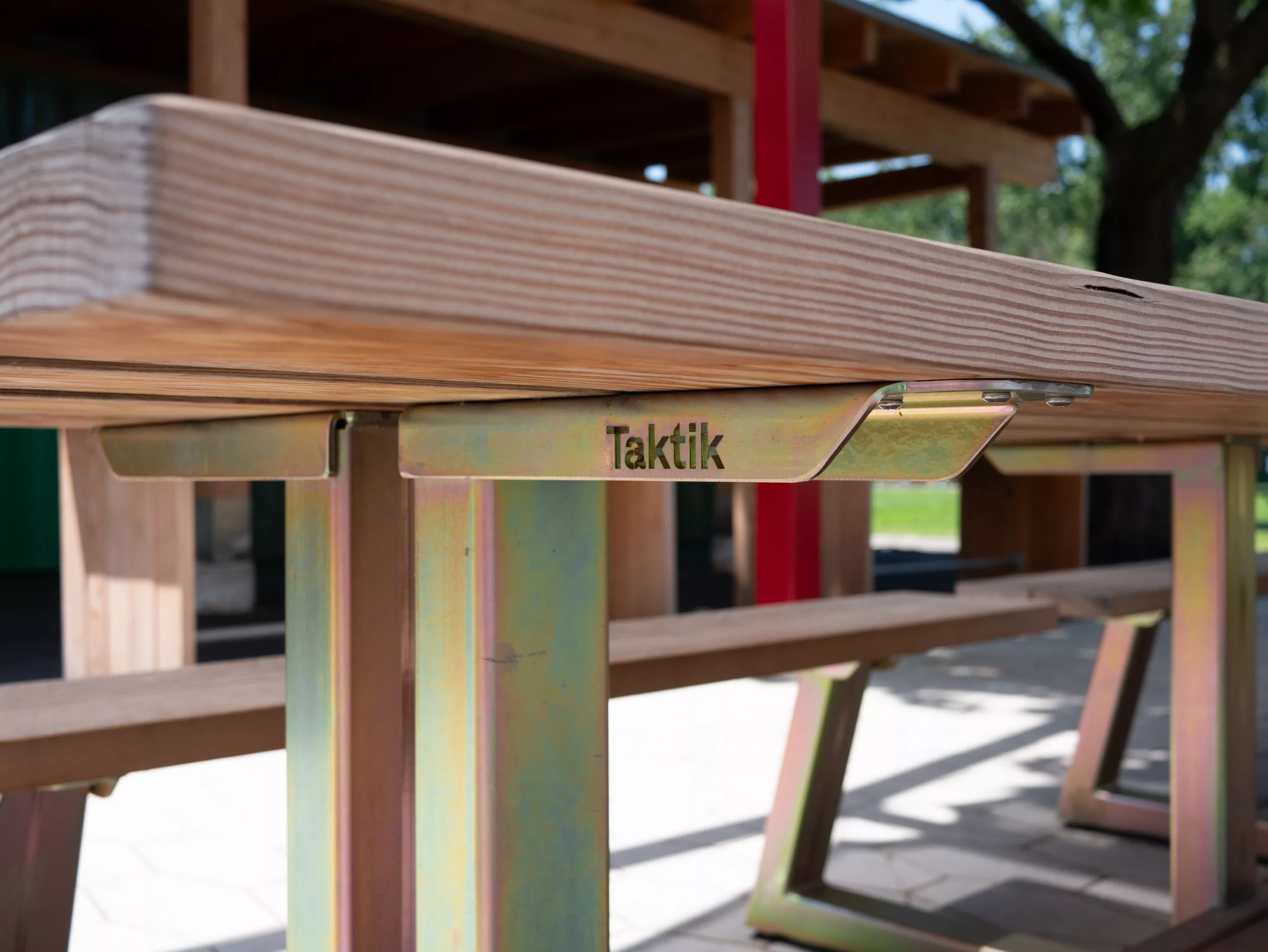 Une table-banquette Picnico sauvage, mobilier d'acier zinqué et de bois clair.