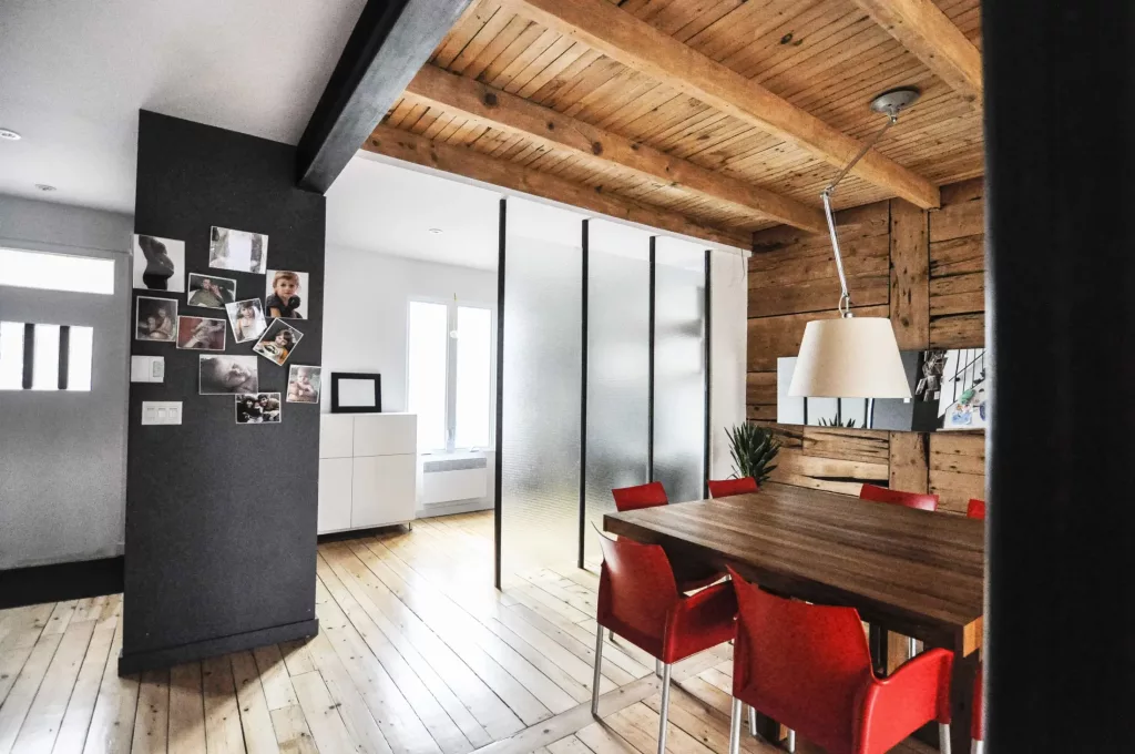 La salle à diner comprend un mur de verre glacé qui crée une coupure avec l'entrée principale du duplex.