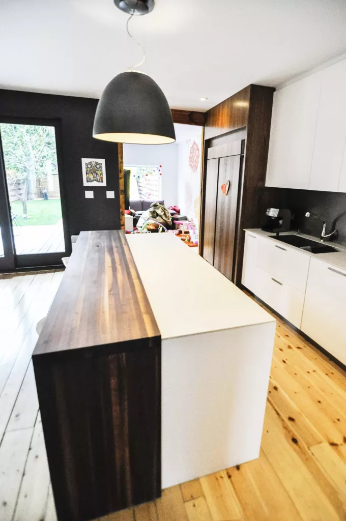 L'ilot de la cuisine du duplex Saint-Vallier est fait d'une partie de bois foncé et de composite blanc.