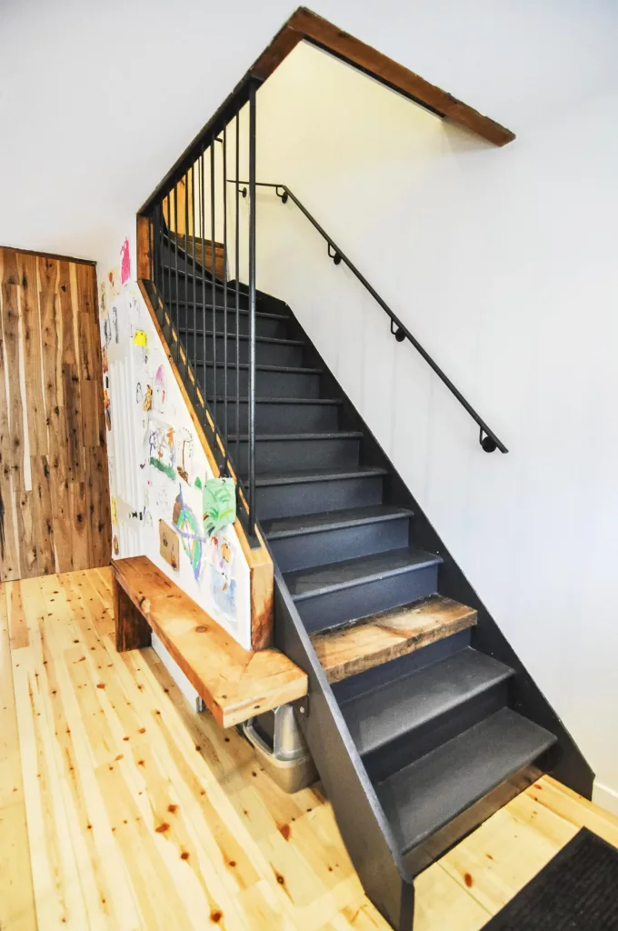 L'escalier du duplex Saint_Vallier comprend une marche de bois, qui se transfome en banc grçace à un angle de coin.