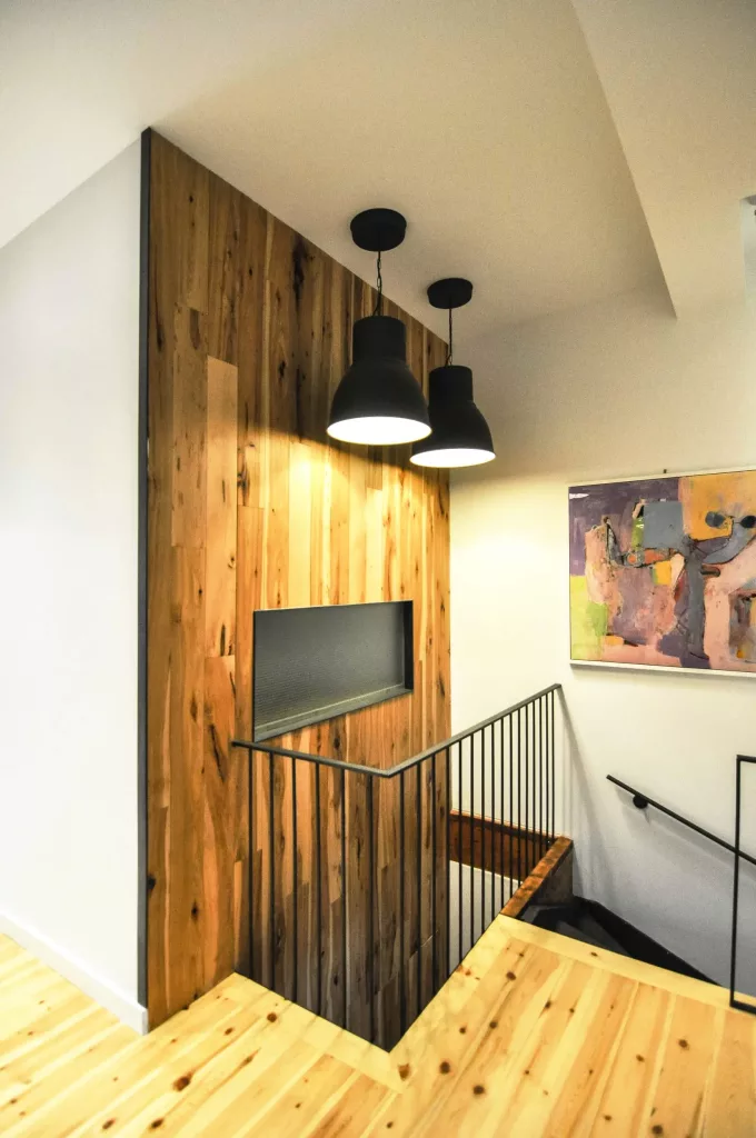 Le coin supérieur de l'escalier du duplex Saint-Vallier  est éclairé par des lampes suspendues industrielles jumelles.