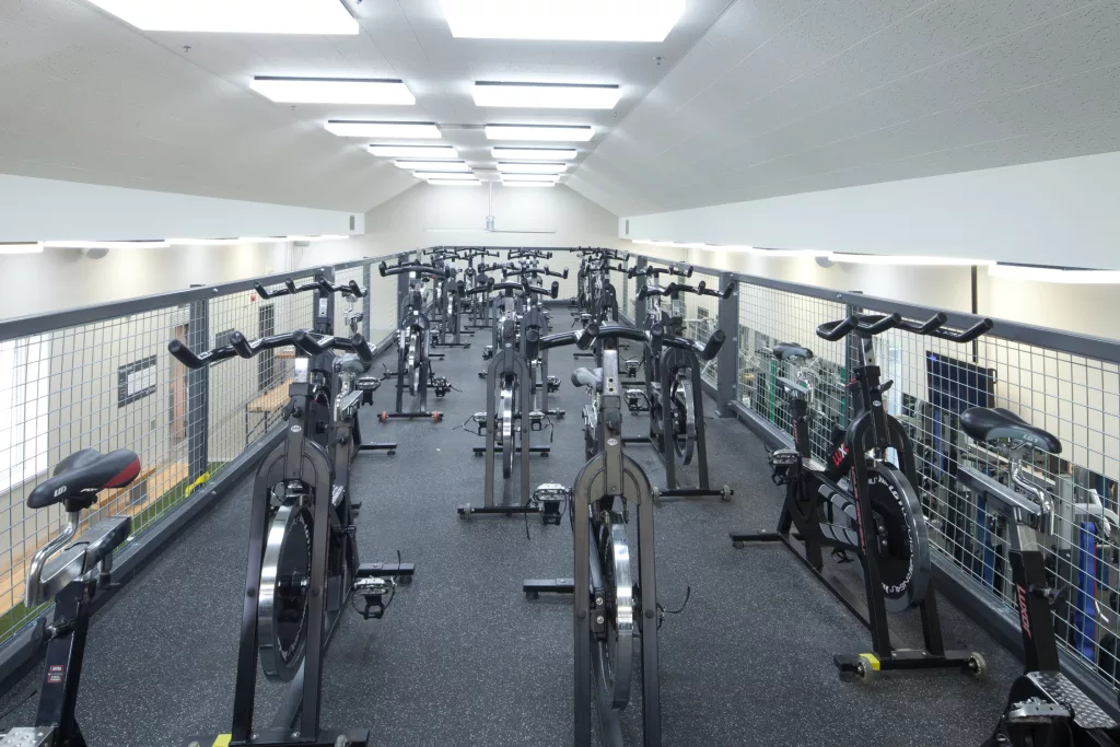 Le haut de la mezzanine de la salle d'entrainement comprent plusieurs vélos stationnaires.