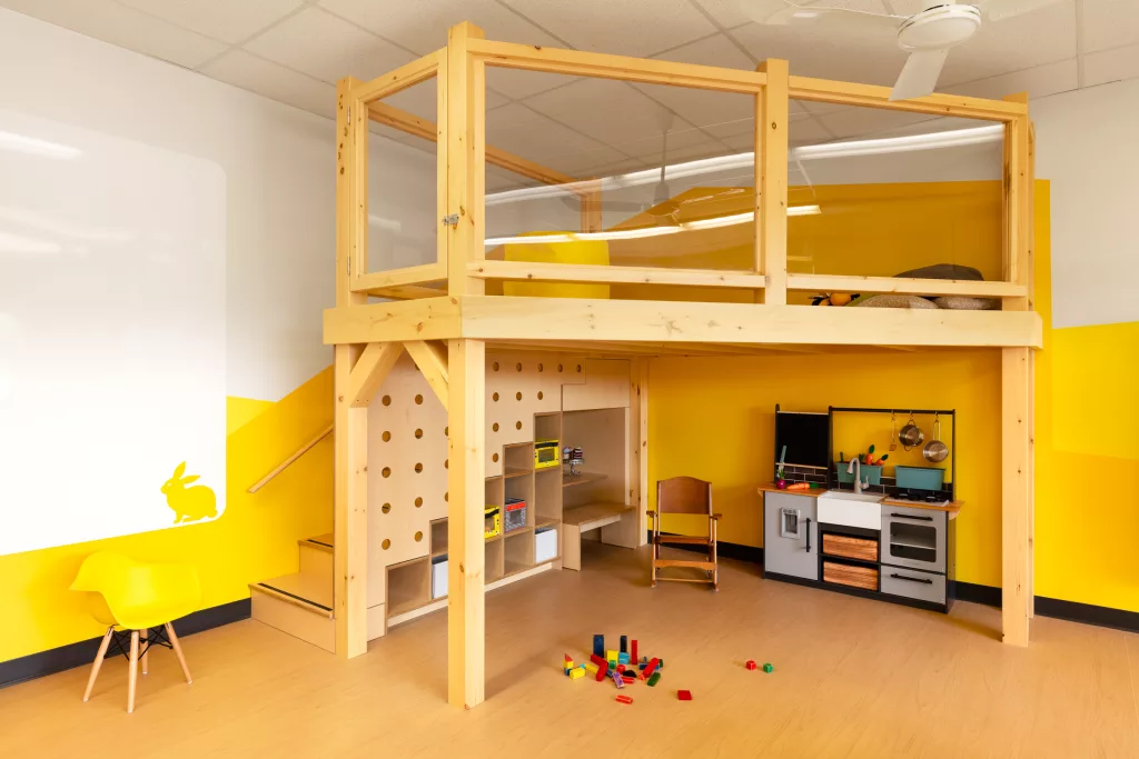 Une mezzanine de bois crée une ambiance de cabane dans une abre à même la classe.