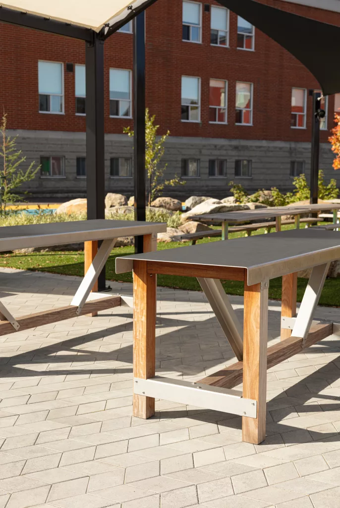 Un gros plan sur des tables comptoir de bois et d'acier inoxydable sous un toit de toile.