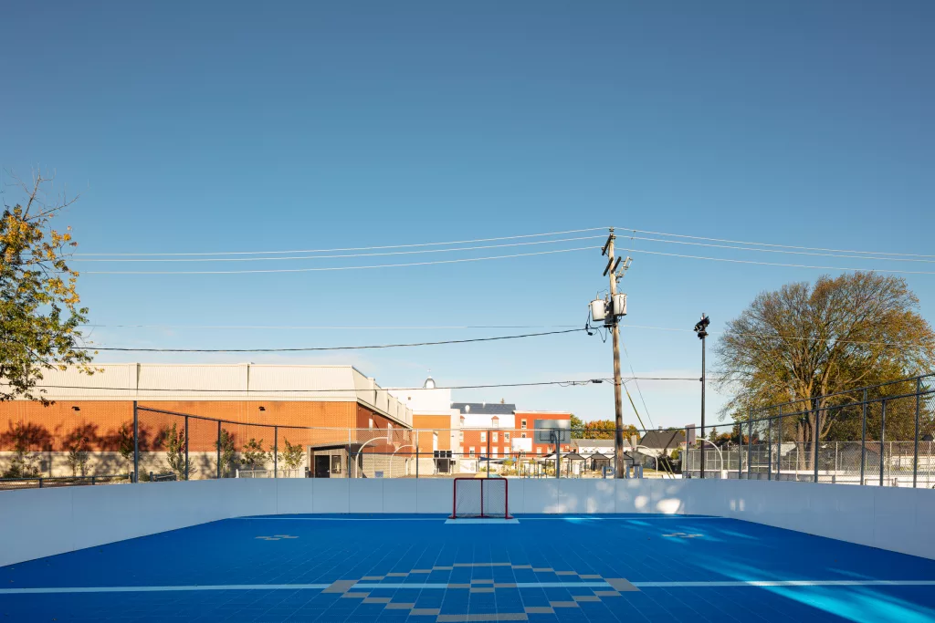 La surface bleue du terrain de dekhockey vue du milieu de la zone opposée. 