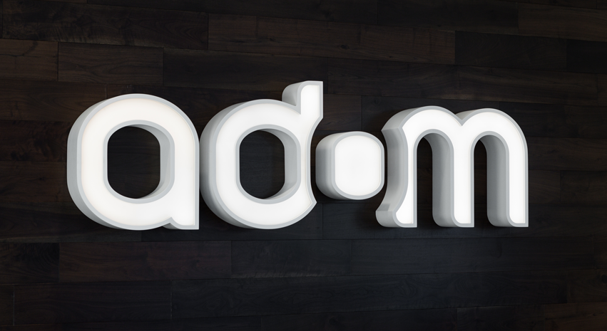 Logo tridimensionnel de la compagnie Adom.