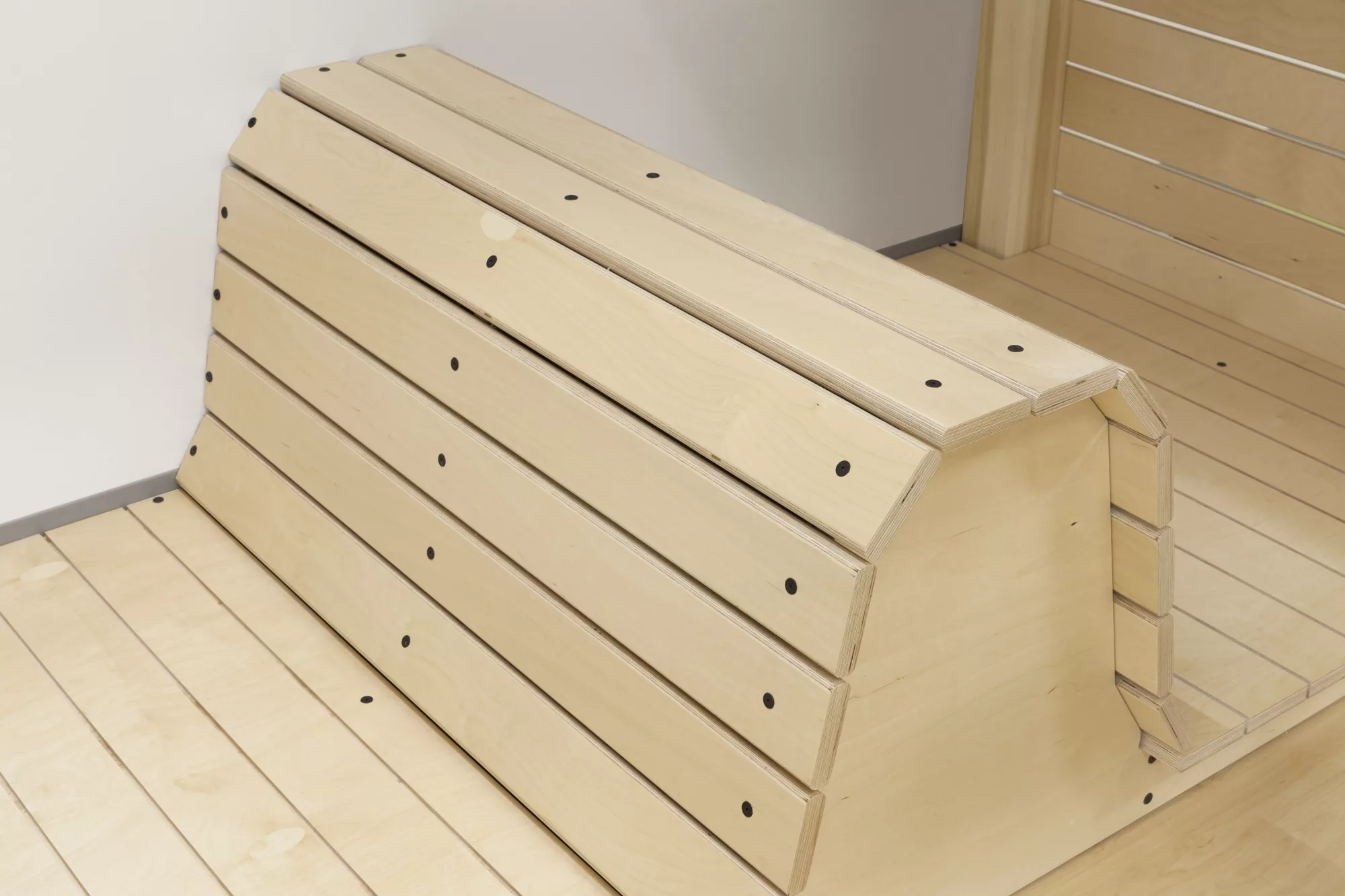 Gros plan sur le dossier d'une banquette en bois créé sur mesure par Taktik Design.