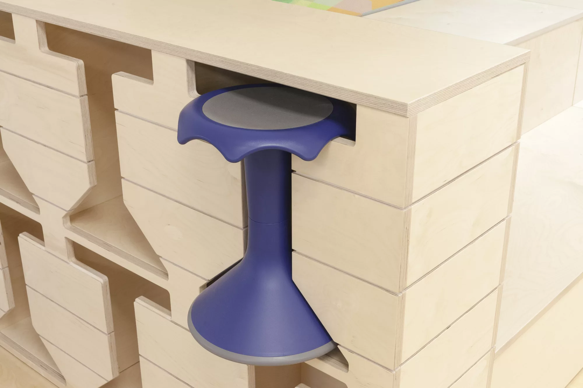 Détail de rangement sur mesure pour les tabourets en bois découpé.
