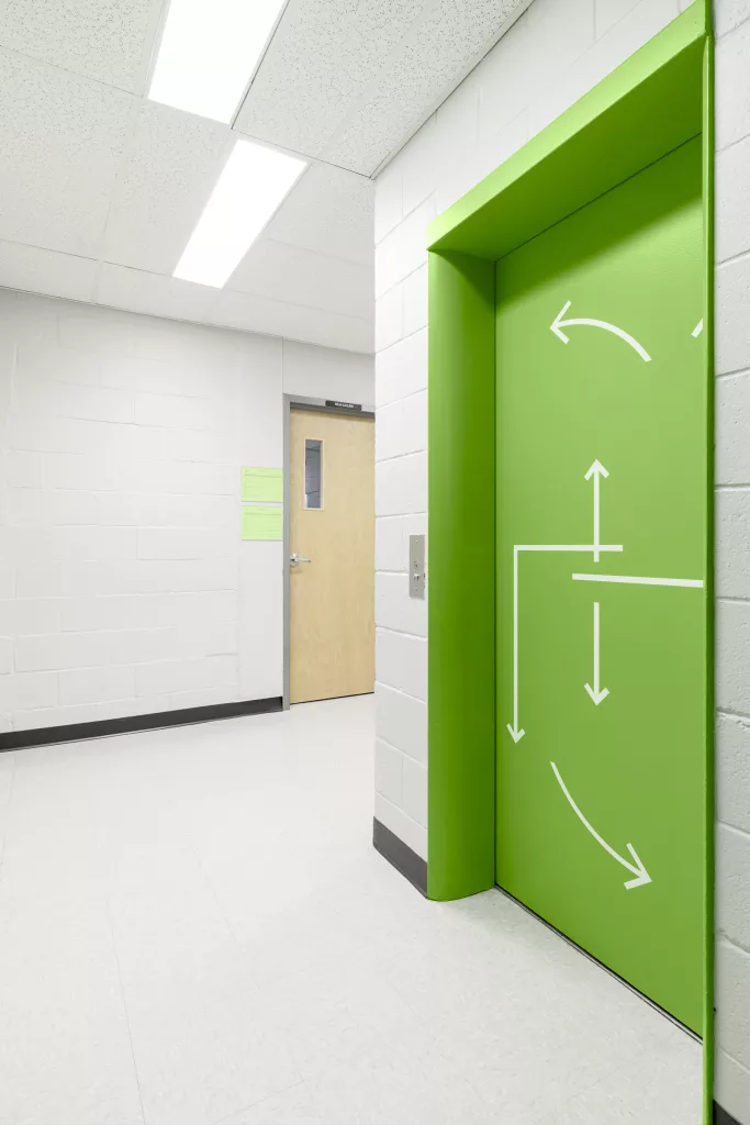 La porte de l'ascenseur du quatrième étage est colorée en vert.