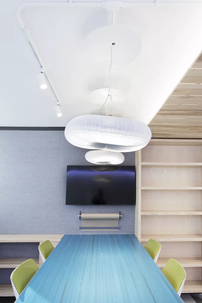 Des lampes designées par Taktk design suspendues au dessus d'une table de travail dans unesalle de formation 
Cadre 21 de la FEEP.