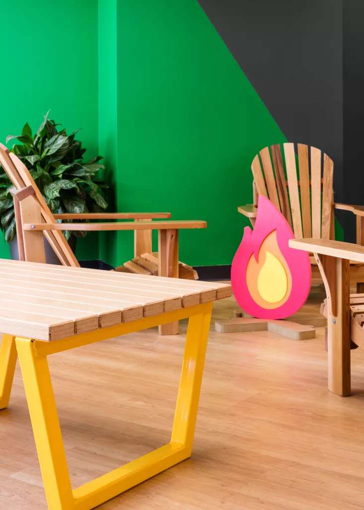 Une autre vue du faux feu de camp entouré de mobilier et de plantes à la bibliothèque du Collège d'Anjou.