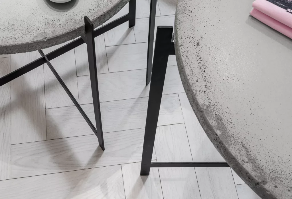 Des tables de béton ayant des pattes d'acier noir de la boutique.