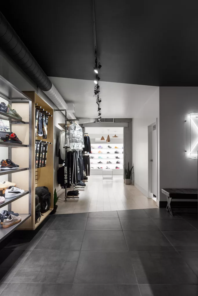 Vue en profondeur des présentoirs de souliers à la boutique Exclucity de Toronto.
