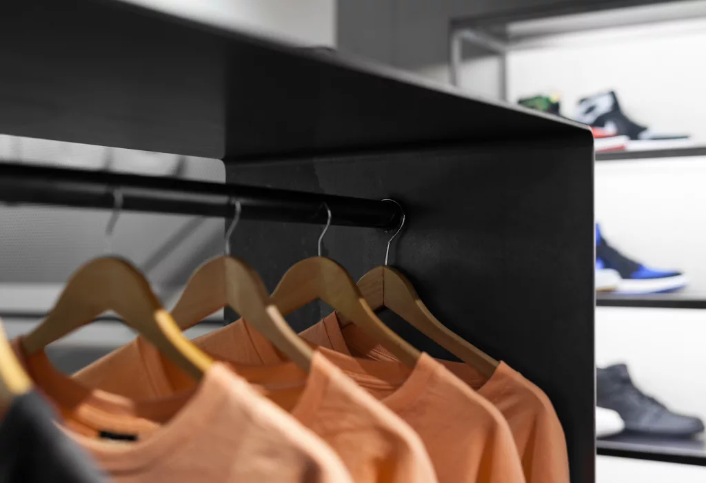 Des vetements alignés sur des supports d'acier de la boutique Exclucity de Toronto.