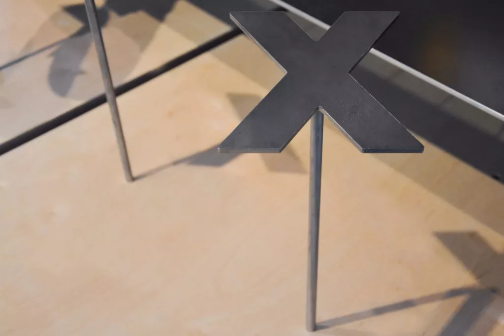 Un support de chaussures en acier découpé à l'effigie de la boutique Exclucity.