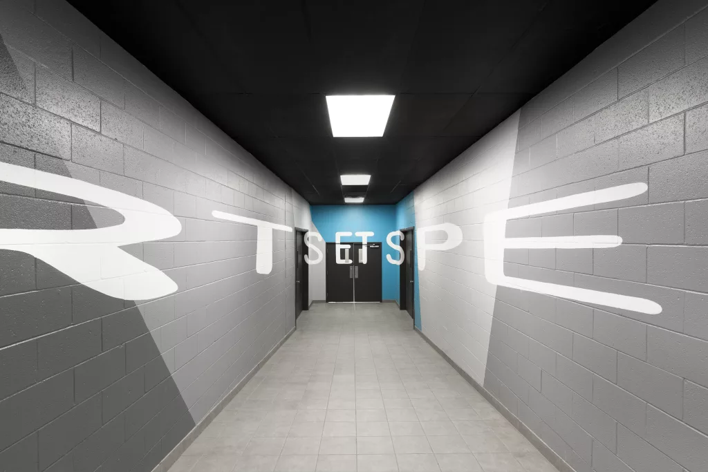 Le couloir menant à l'auditorium de l'externat aux couleur dynamiques ou l'on peut lire en grosses lettres: Arts et spectacles.
