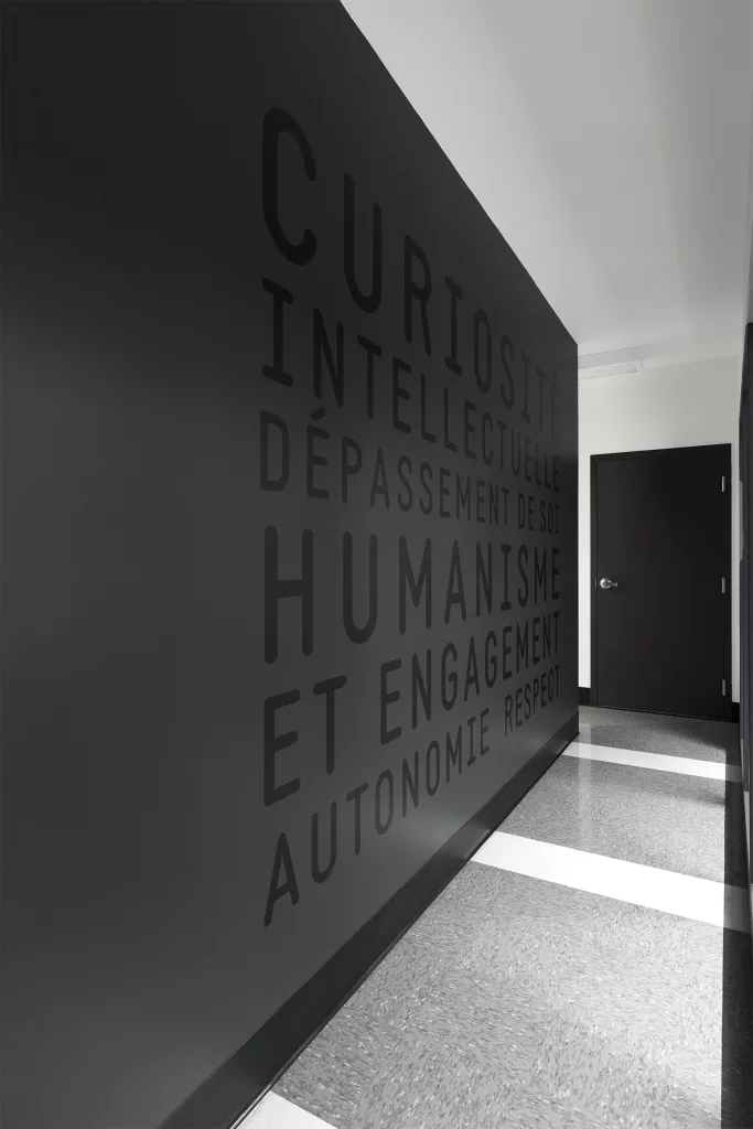 Un mur de couleur foncé ou apparaissent des qualités inspirantes en ton sur ton.