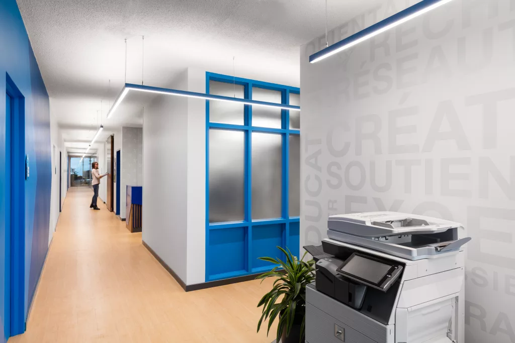 Un couloir de l'édifice à bureaux de la FEEP, ou des tons mureaux de  gris pâle s'agencent aux bleus de l'image de marque de l'organisation.