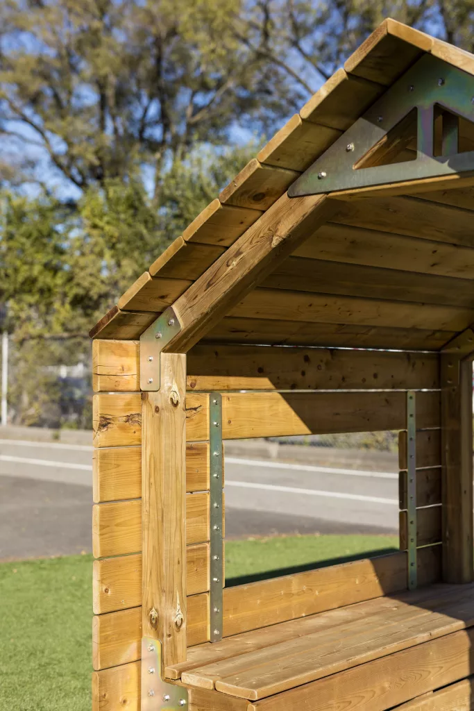 Une cabane de bois munie de bancs et de fenêtres.