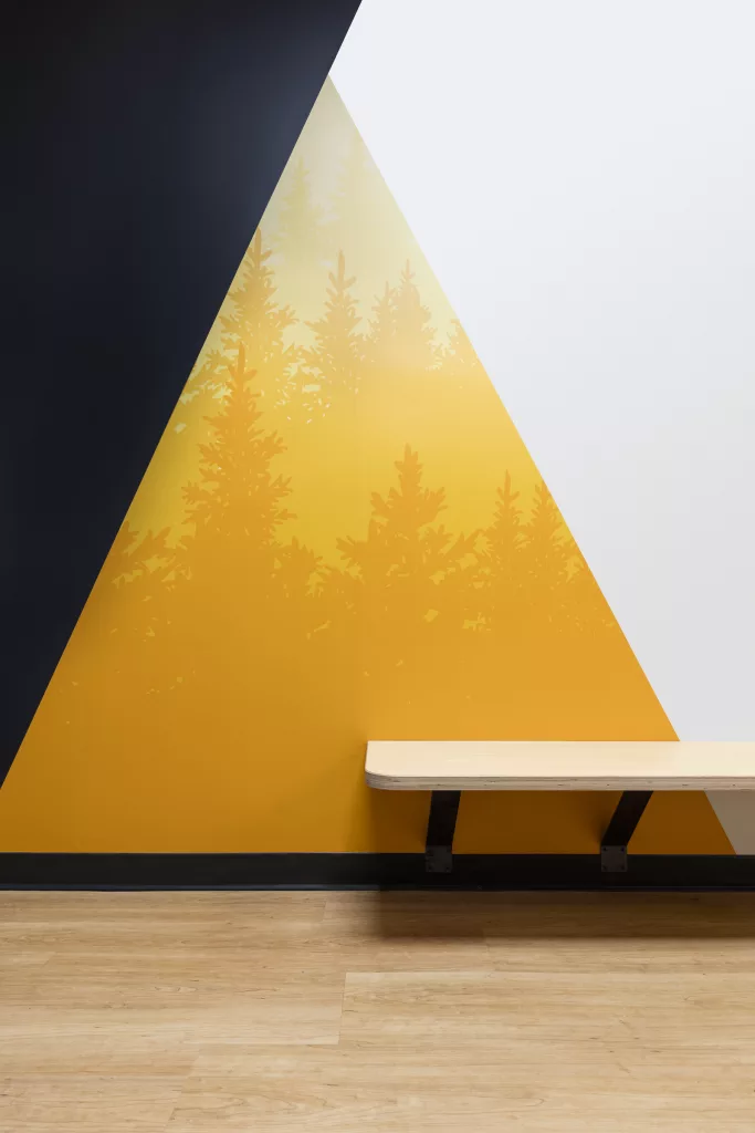 Un banc apposé au mur dans l'un des corridors colorés du Séminaire Sacré-Coeur.