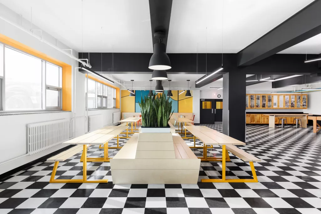 Un salon étudiant contenant du mobilier modulable et coloré et des murales au Séminaire Sacré-Coeur.