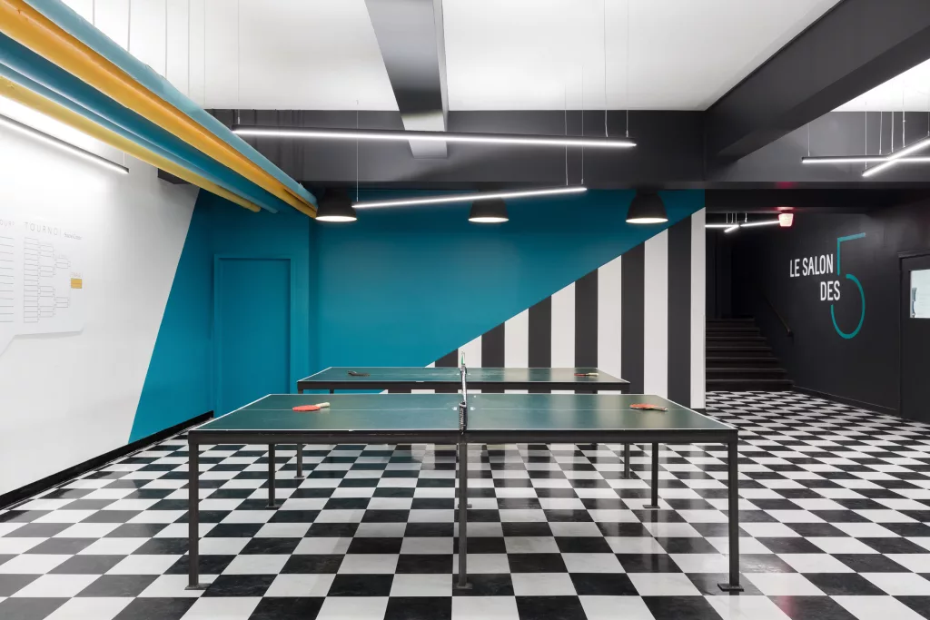 Le salon des 5 du Séminaire Sacré-Coeur comprend deux tables de ping-pong et des murs colorés.