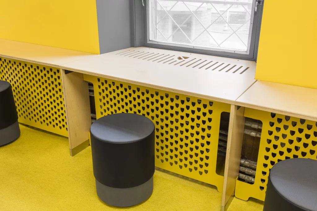 Du mobilier comprenant de petits bancs cylindriques dans une salle de classe second étage du collège Sainte-Anne.