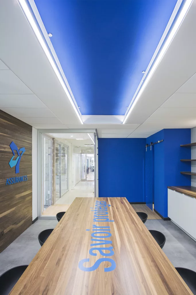Vue d'une salle de réunion du bureau des assurances de la FEEP, ou la couleur bleue du logo colore le mur du fond et une partie du plafond.