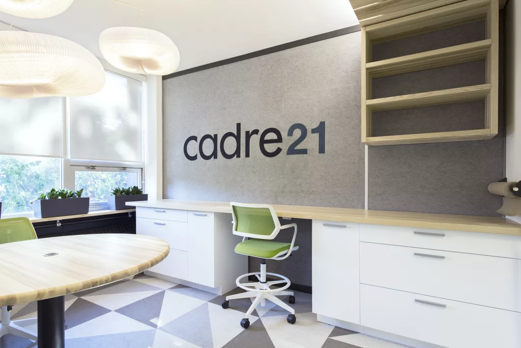 Un bureau devant un babillard feutré d'une salle de formation 
Cadre 21 du FEEP.