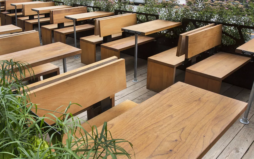 Une vue sur les multiples banquettes de bois de la terrasse du bar Miss Villeray.