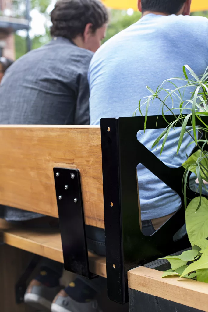 La terrasse du bar Miss Villeray est majoritairement faite de bois et d'acier peint en noir.