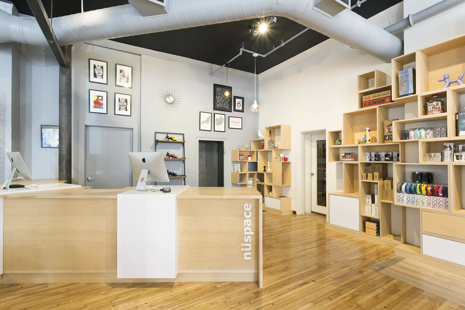 Le comptoir caisse et les étagères de cubes de bois clairs superposées de la boutique Nüspace.