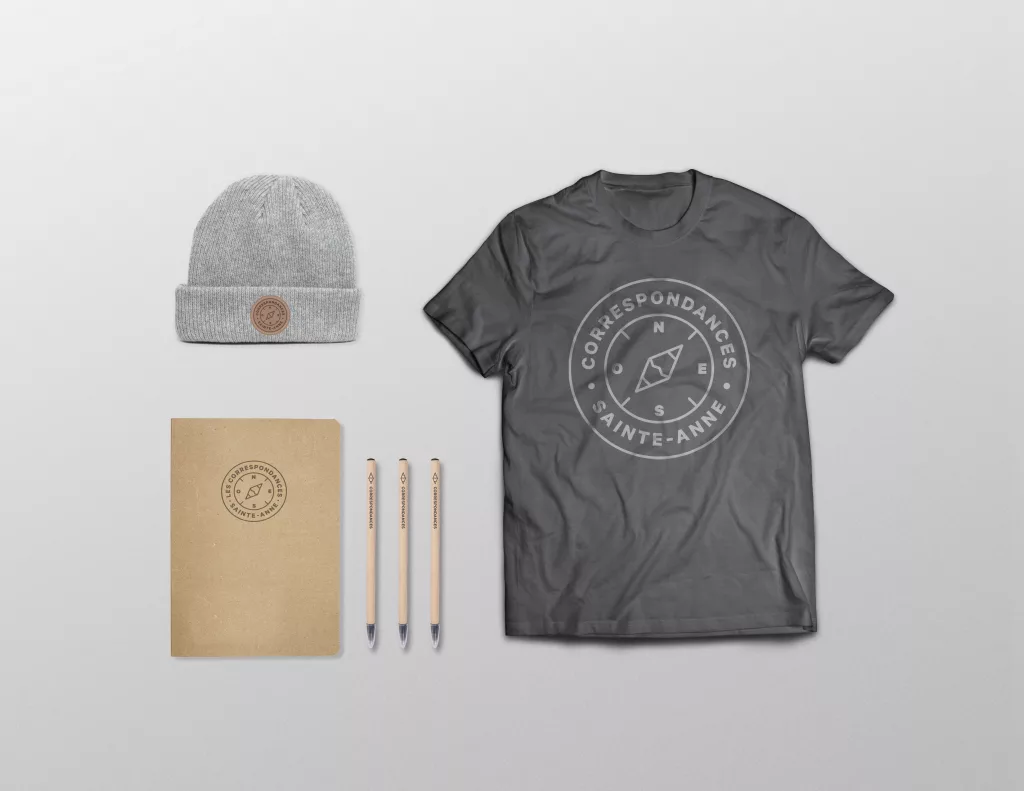Une tuque, des crayons de bois, ue enveloppe de papier et un t-shirt arborant le logo du programme Les Correspondances.