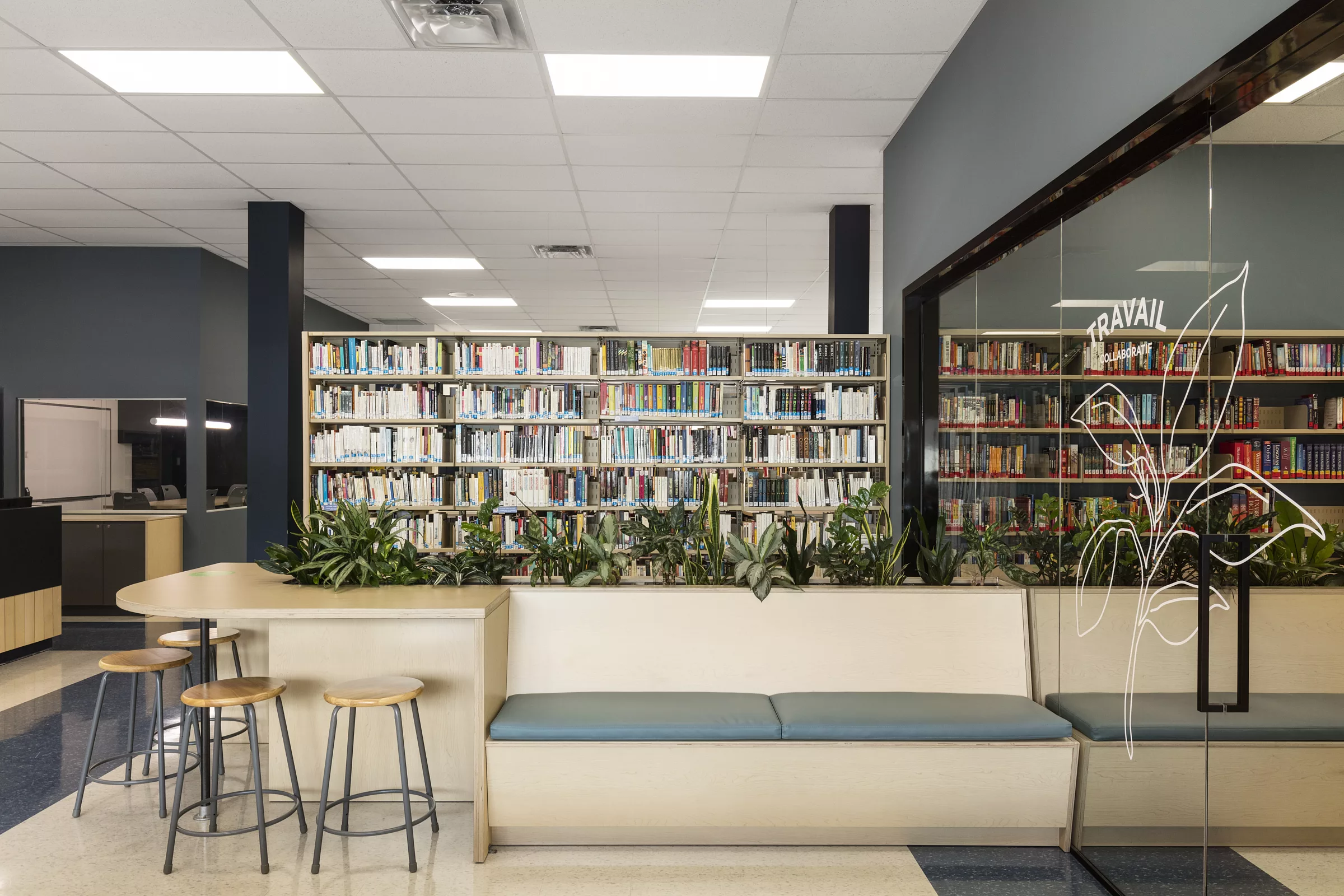 Une vue de la bibliothèque du Collège Saint-Hilaire. On y voit des banquettes devant des rayons de livres.