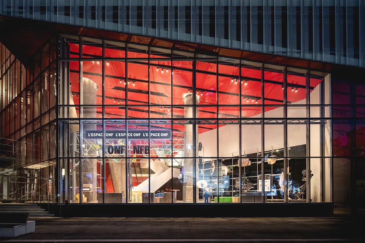 Une vue extérieure de nuit de la vitrine de l'ONF, dans l'ilôt Balmoral à Montréal.