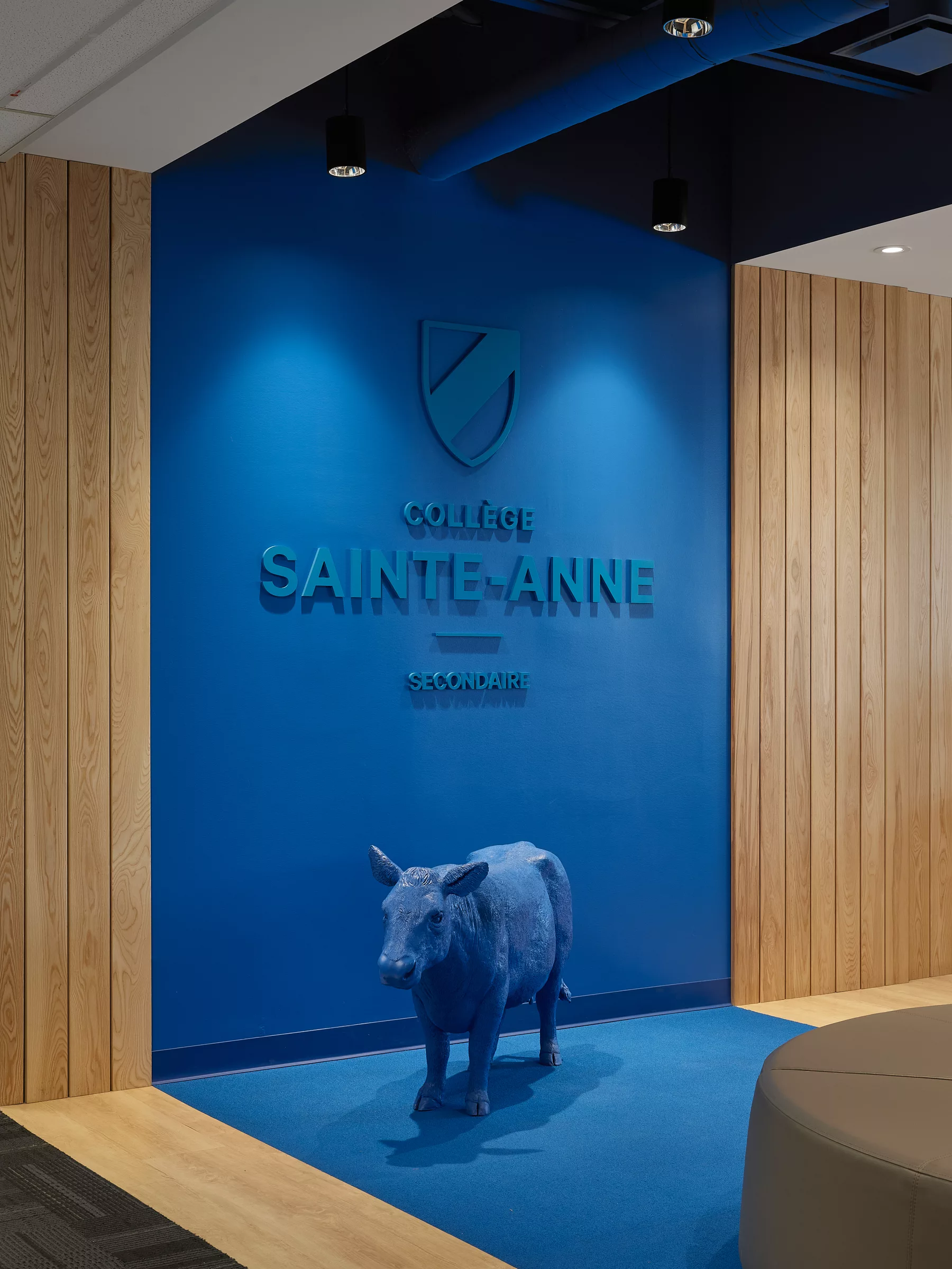 Une vue rapprochée du logo de l'école et d'une vache sculptée au Collège Sainte-Anne, Pavillon Marie Esther.