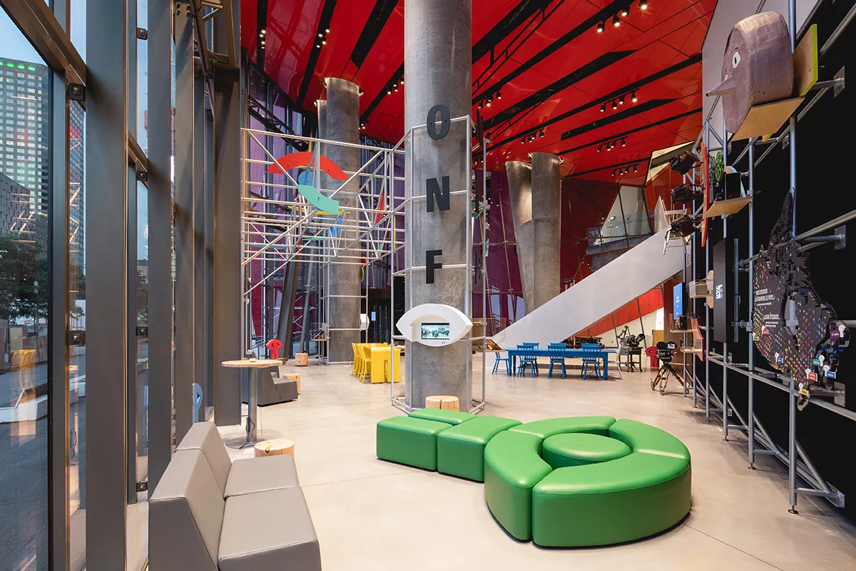 Une vue générale de l'aménagement de l'accueil de l'ONF à l'ilôt Balmoral à Montréal. On y voit la banquette créée sur mesure en forme du logo de l'ONF.