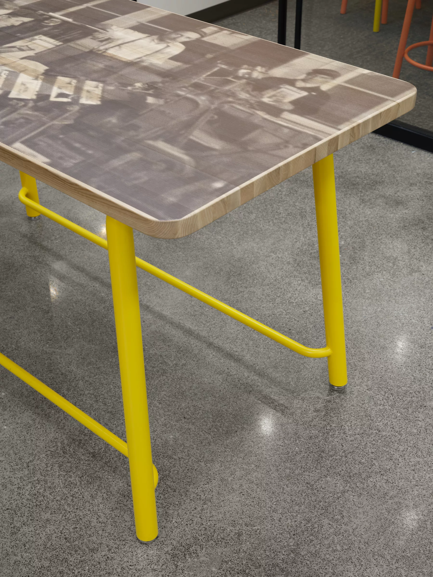 Détail d'une table en bois imprimée avec une photo historique du Collège.