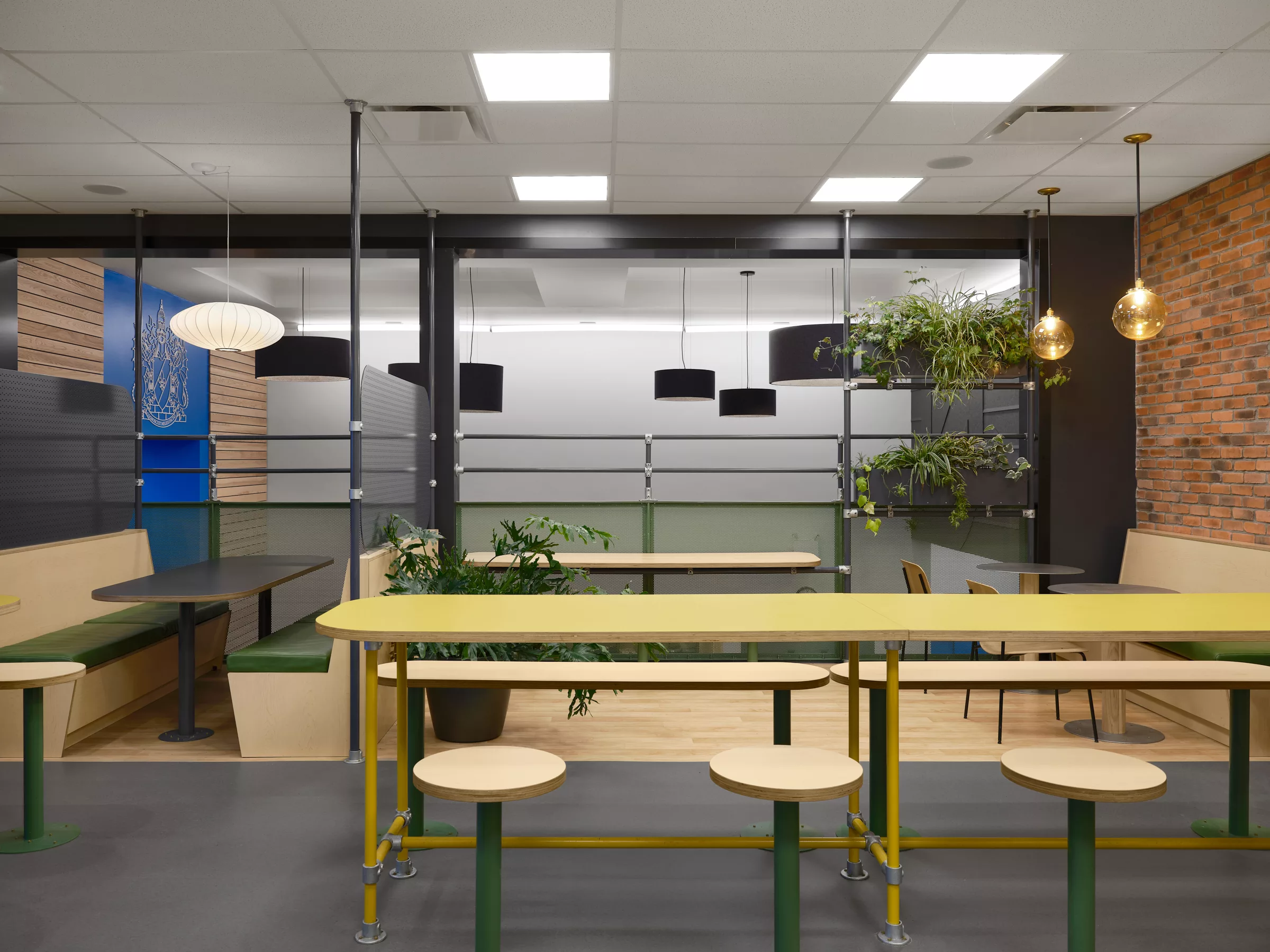 Détail de mobilier du nouvel espace mezzanine aménagé au Collège Sainte-Anne par Taktik Design. On y voit un mur en briques, des plantes et du mobilier.