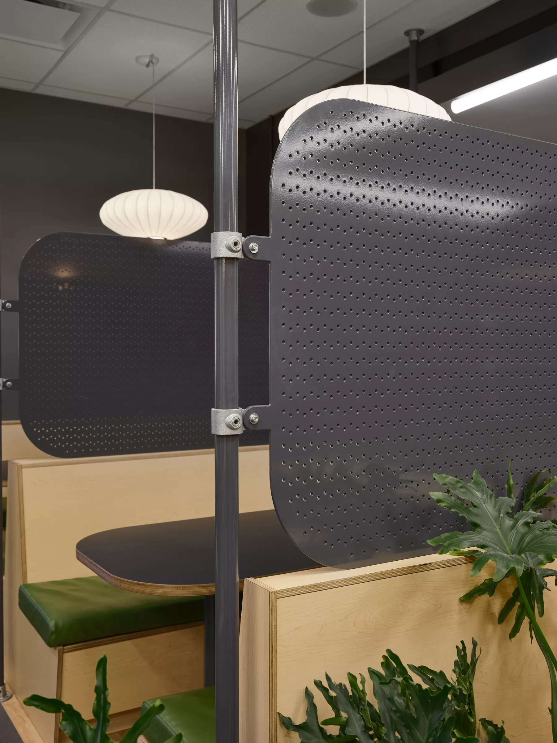 Détail de mobilier du nouvel espace mezzanine aménagé au Collège Sainte-Anne par Taktik Design. On y voit un mur en briques, des plantes et du mobilier.